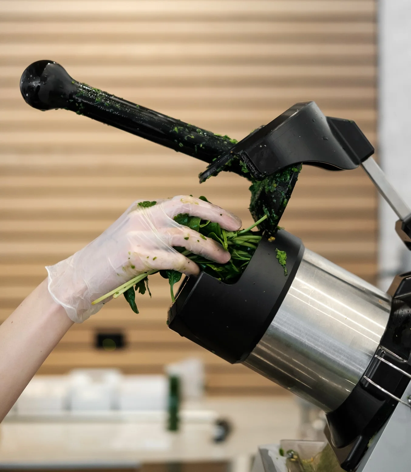 Chef preparing fresh greens in a commercial juicer