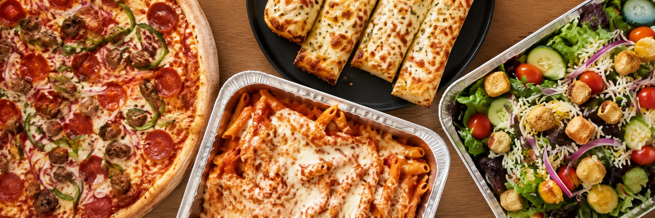 Italian feast with pepperoni pizza, pasta, garlic bread, and fresh salad