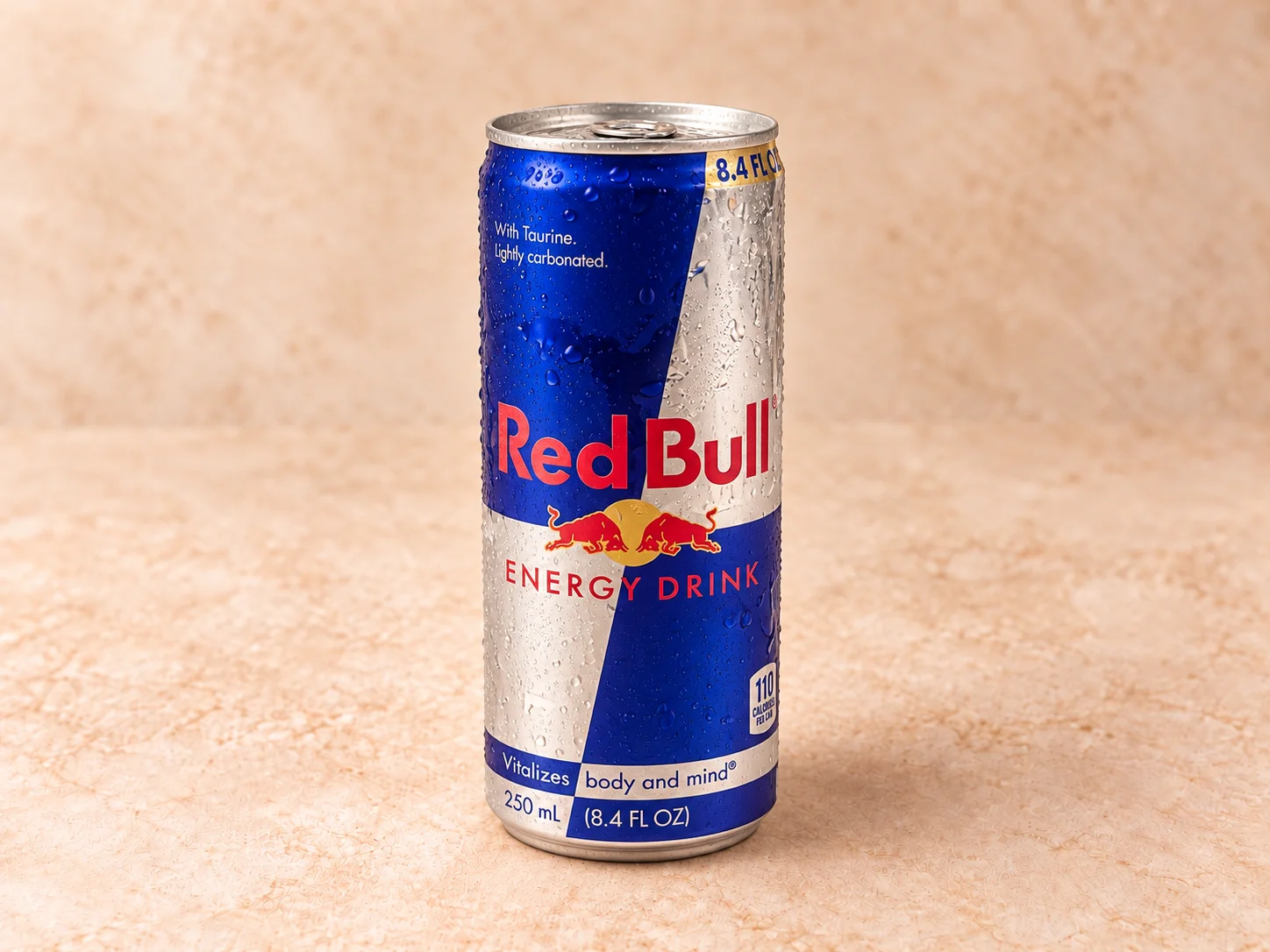 A blue and silver aluminum can of an energy drink, showing droplets of condensation.