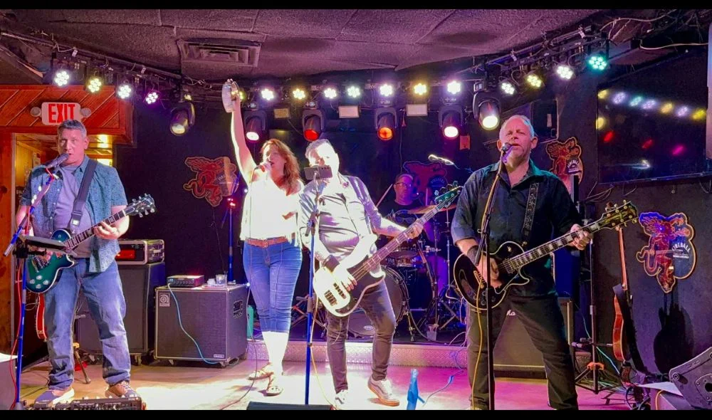 Live band performing on stage with colorful lights