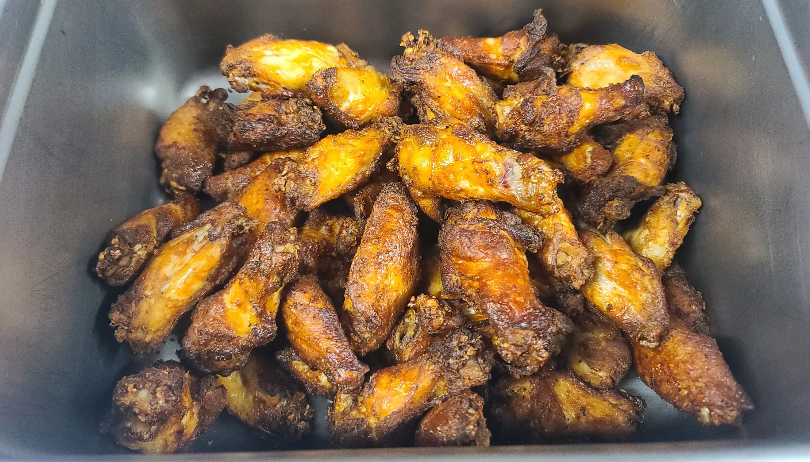 Crispy buffalo chicken wings in a serving tray