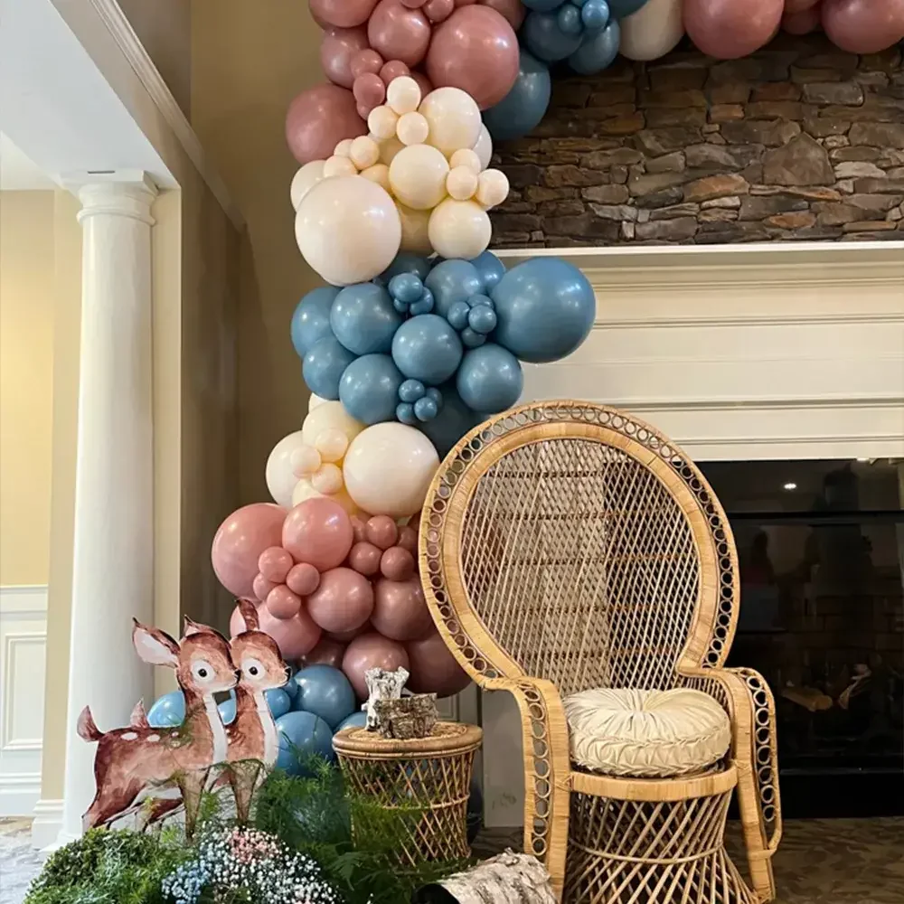 A colorful balloon decoration in soft pastels with a charming wicker chair and decorative elements in a cozy setting.
