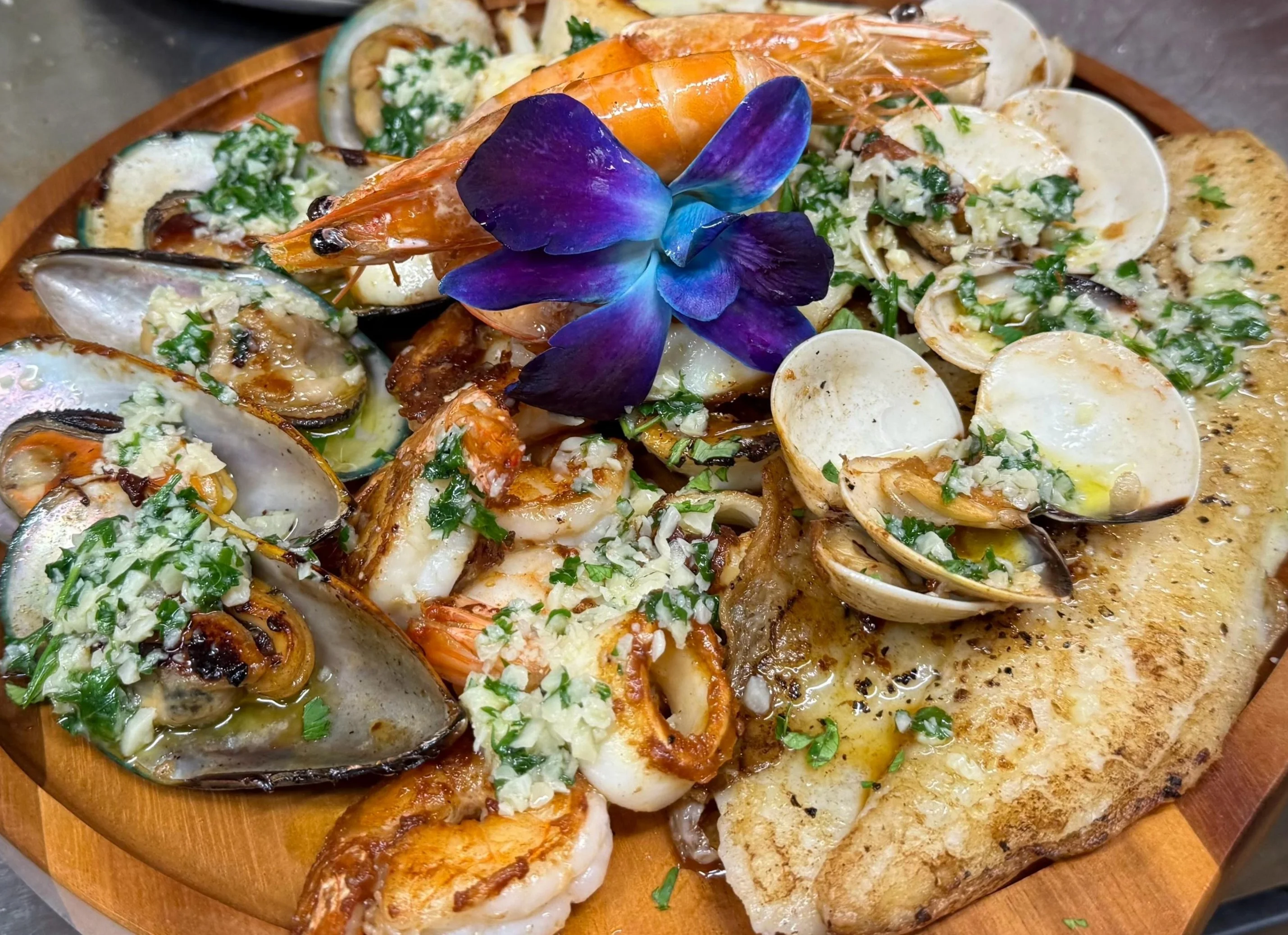 Grilled meats and vegetables served on a sizzling platter.