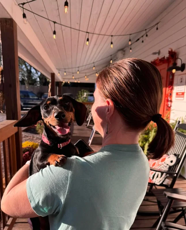 Woman holding dog at beer brewery and resturant
