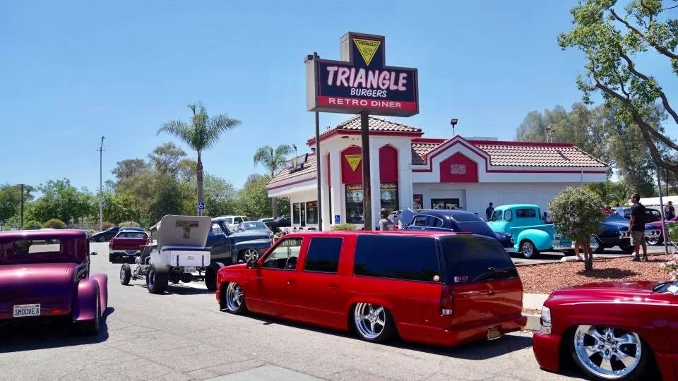 Retro diner exterior with classic cars parked outside