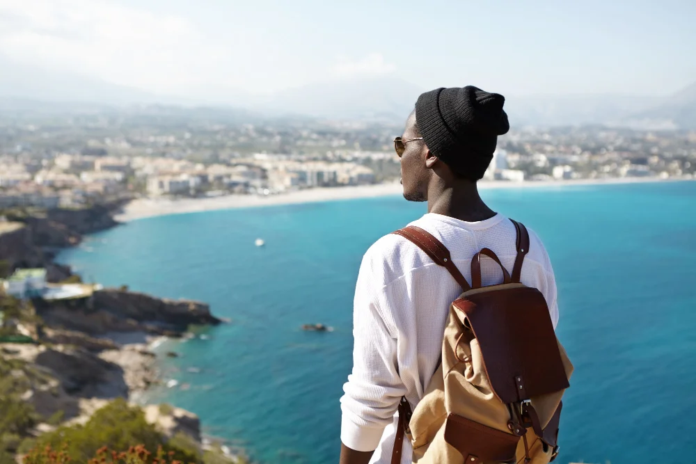 Traveler overlooking a coastal city with a backpack