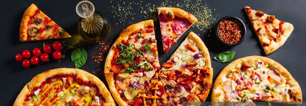 Variety of gourmet pizzas on a dark table
