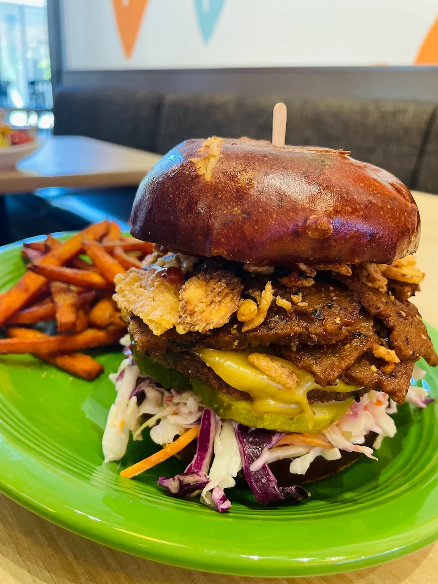 A hearty burger topped with cheddar cheese, jalapenos, and crispy onions, served with fries.