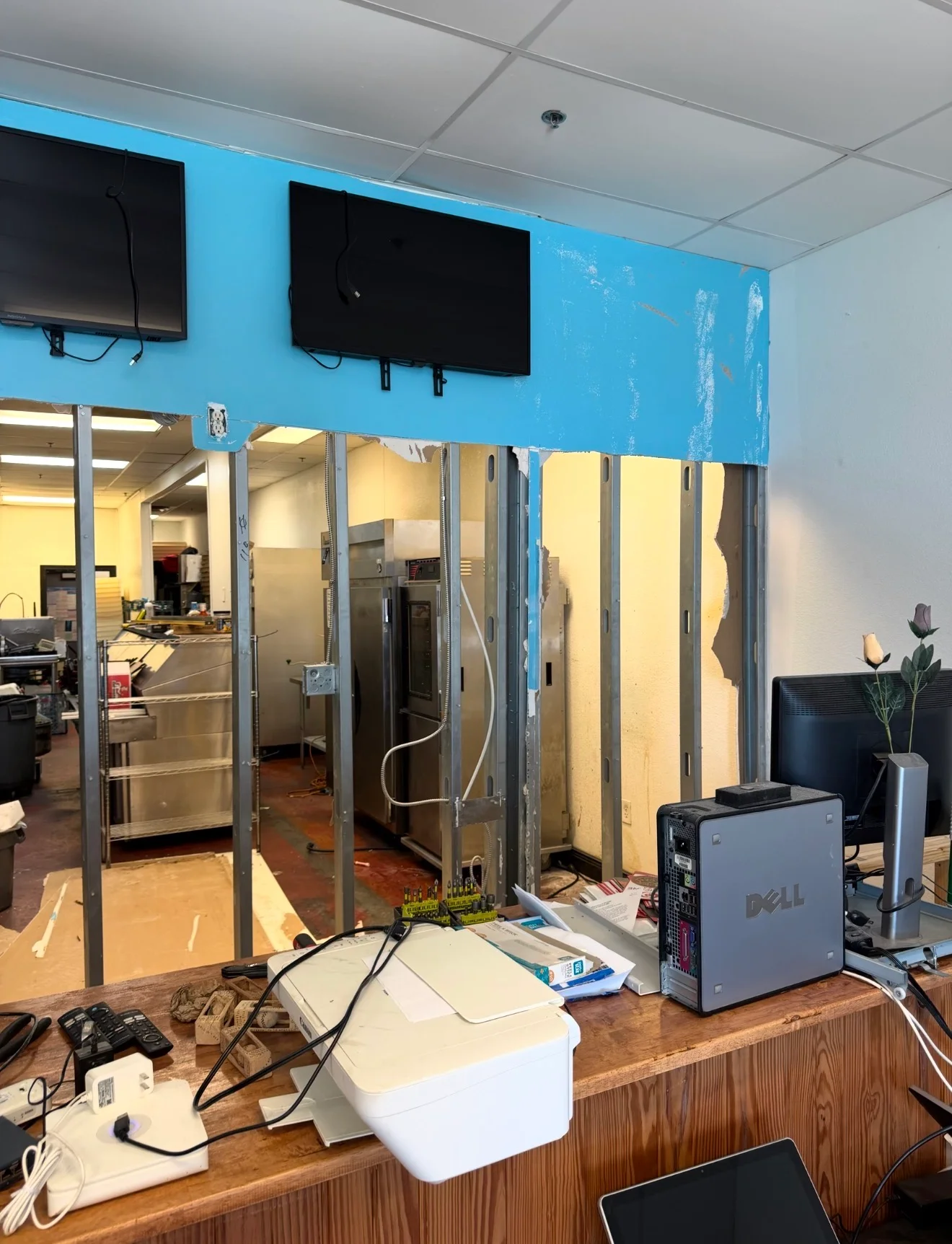 Restaurant interior under renovation with exposed framing and kitchen equipment