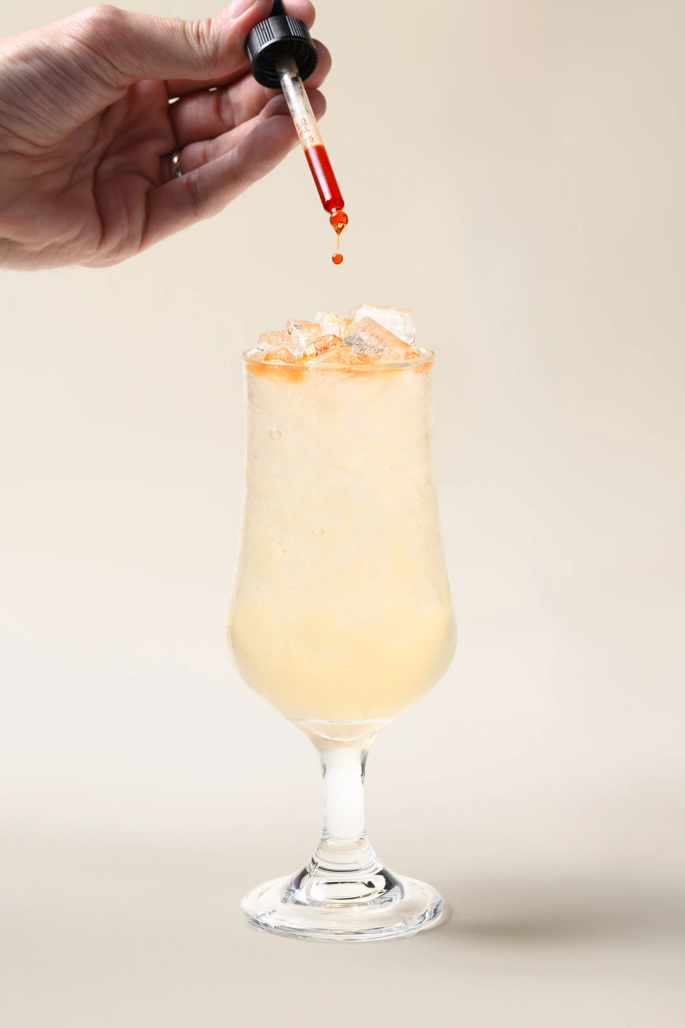 Bartender adding bitters to a refreshing cocktail