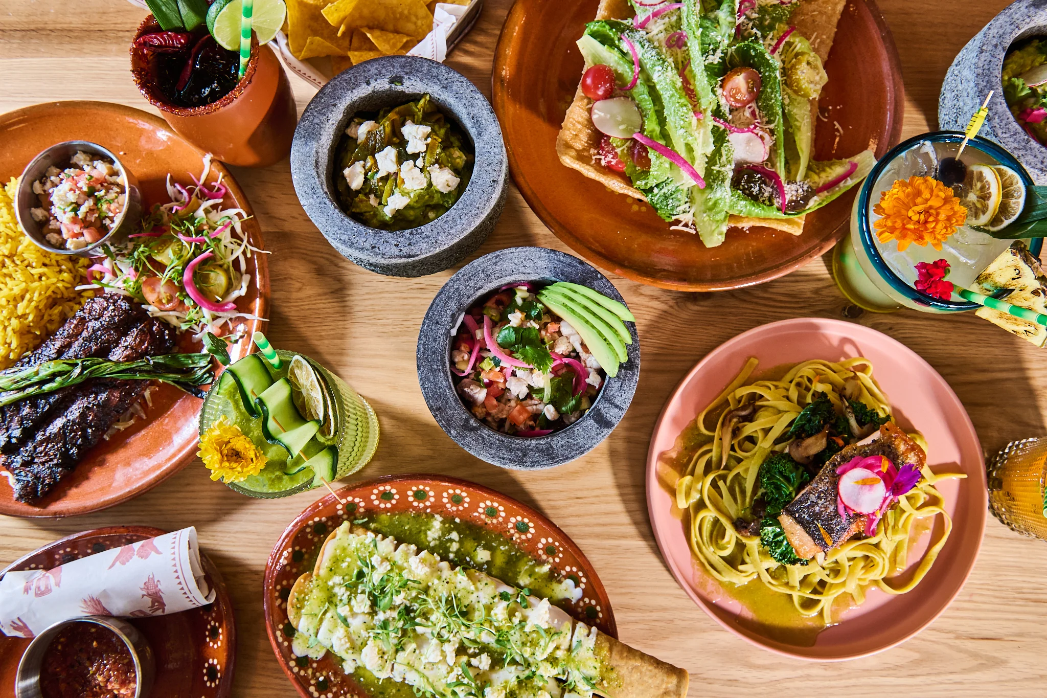Colorful Mexican feast with tacos, enchiladas, and cocktails