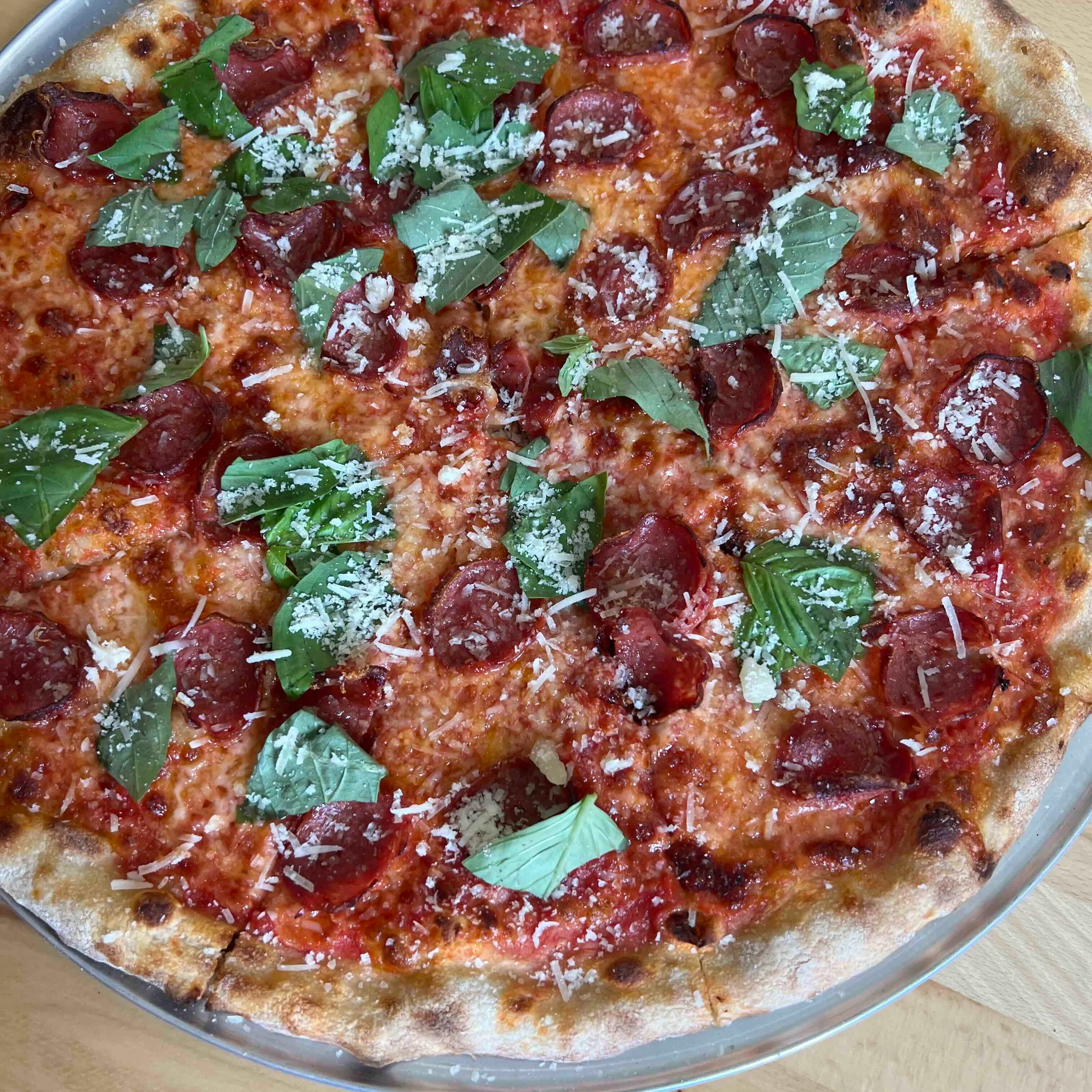 Pepperoni pizza with fresh basil and cheese