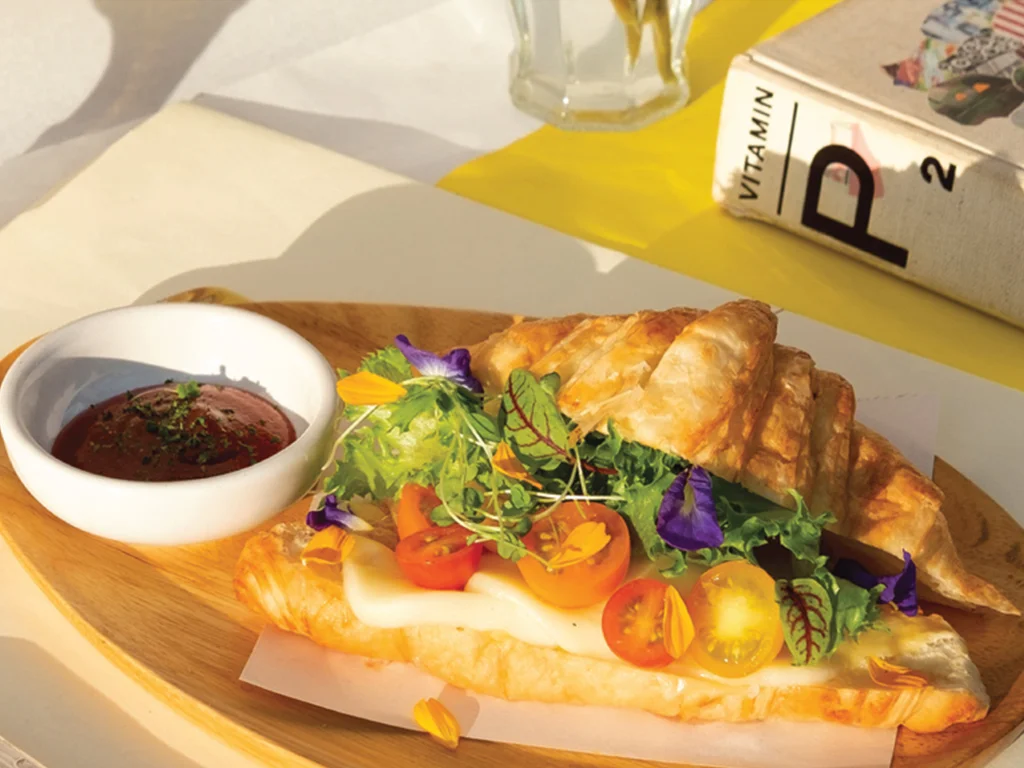 Croissant sandwich with fresh greens and cherry tomatoes