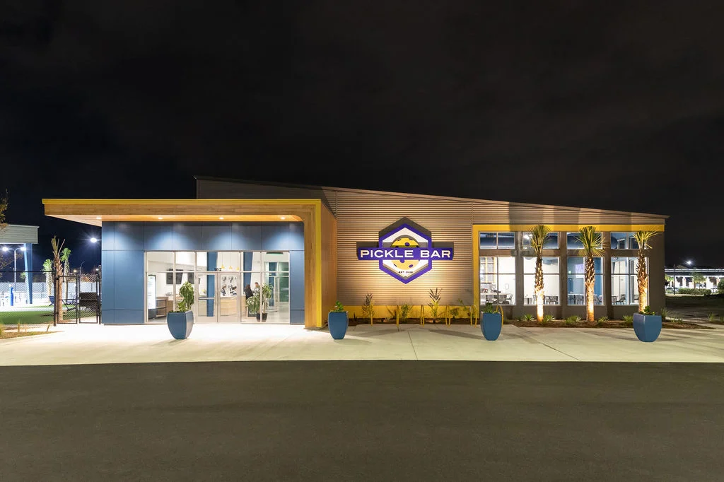 Modern restaurant exterior of Pickle Bar at night