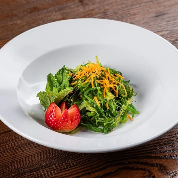 Refreshing seaweed salad with strawberries and mint garnish