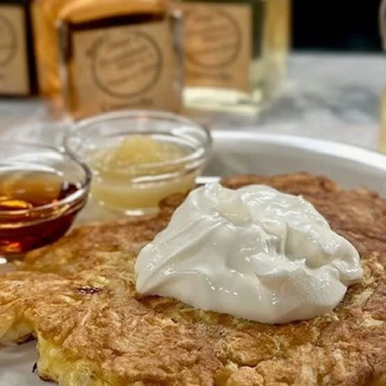 Savory potato latke topped with sour cream and served with applesauce