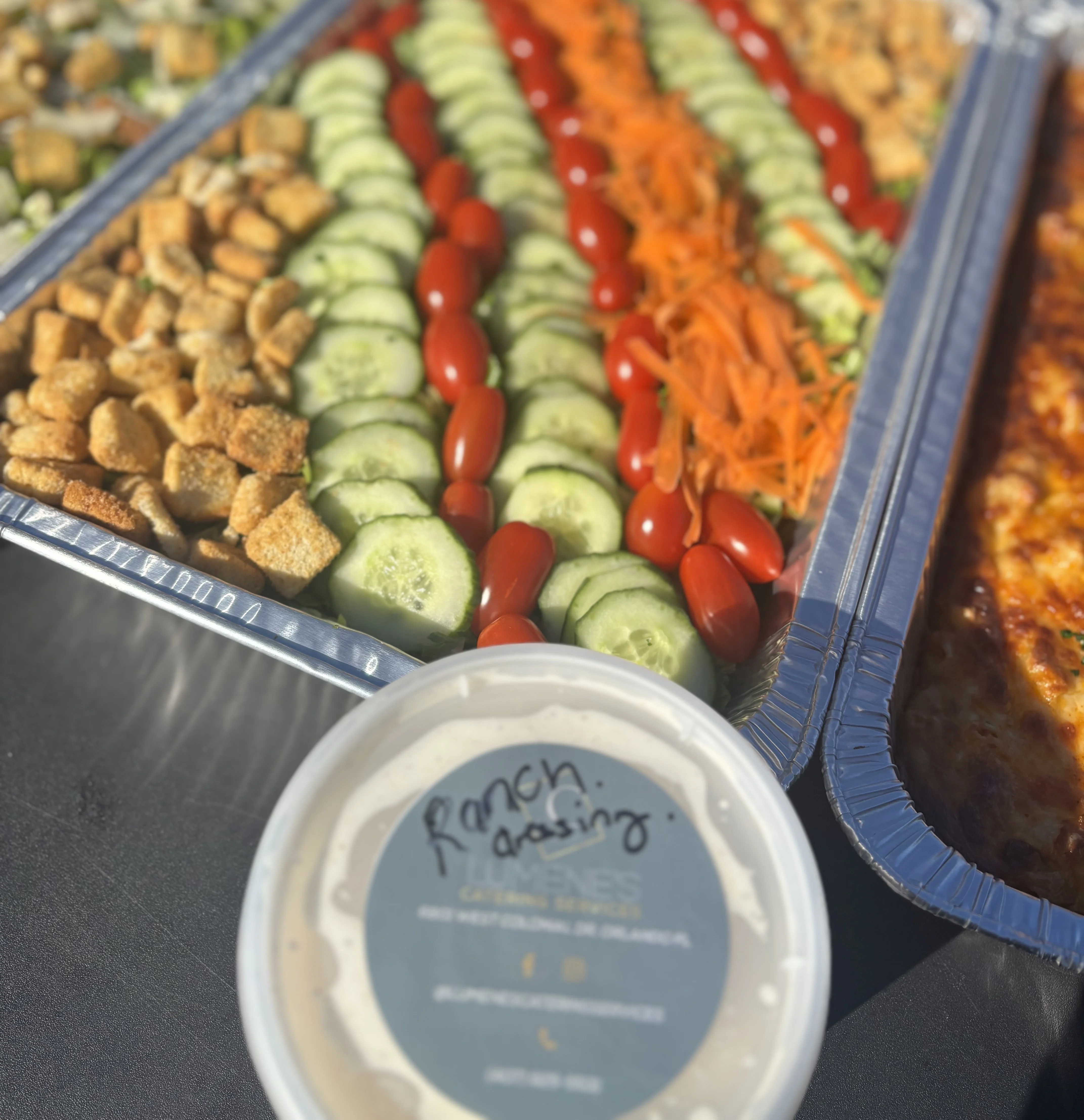 An organized platter featuring an array of fresh vegetables such as cucumbers, cherry tomatoes, and carrots, accompanied by ranch dressing.