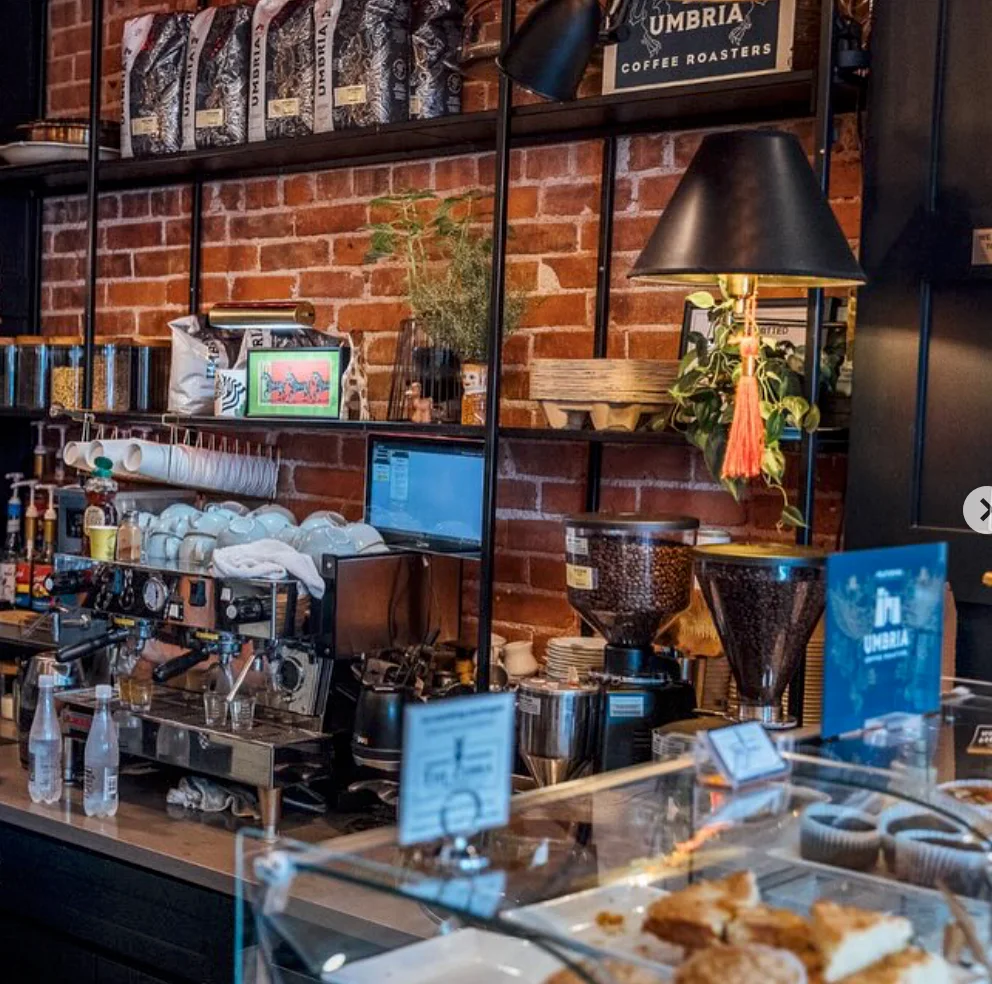 Bartender preparing drinks in a stylish café with brick walls