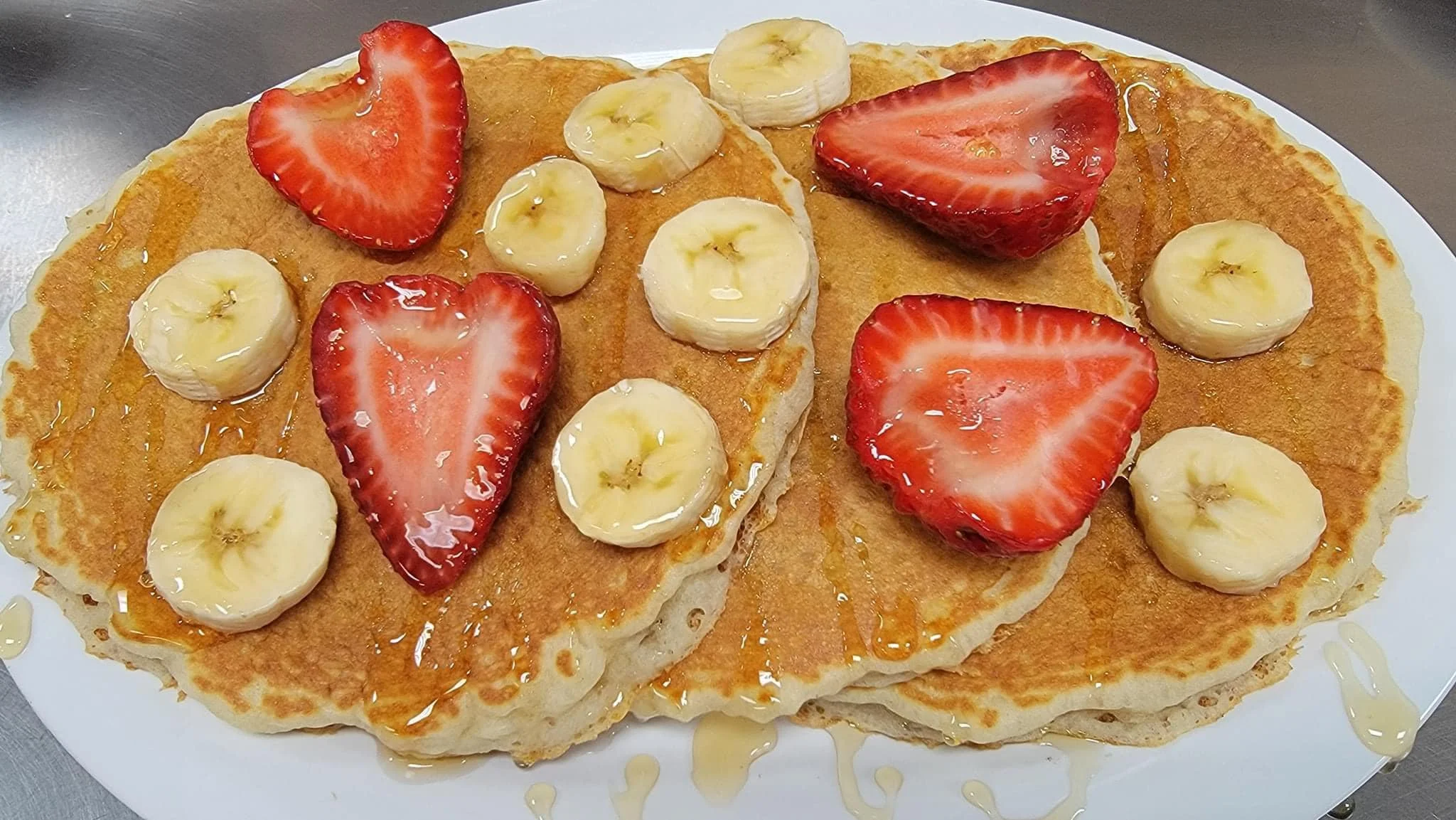 Fluffy pancakes topped with strawberries and bananas