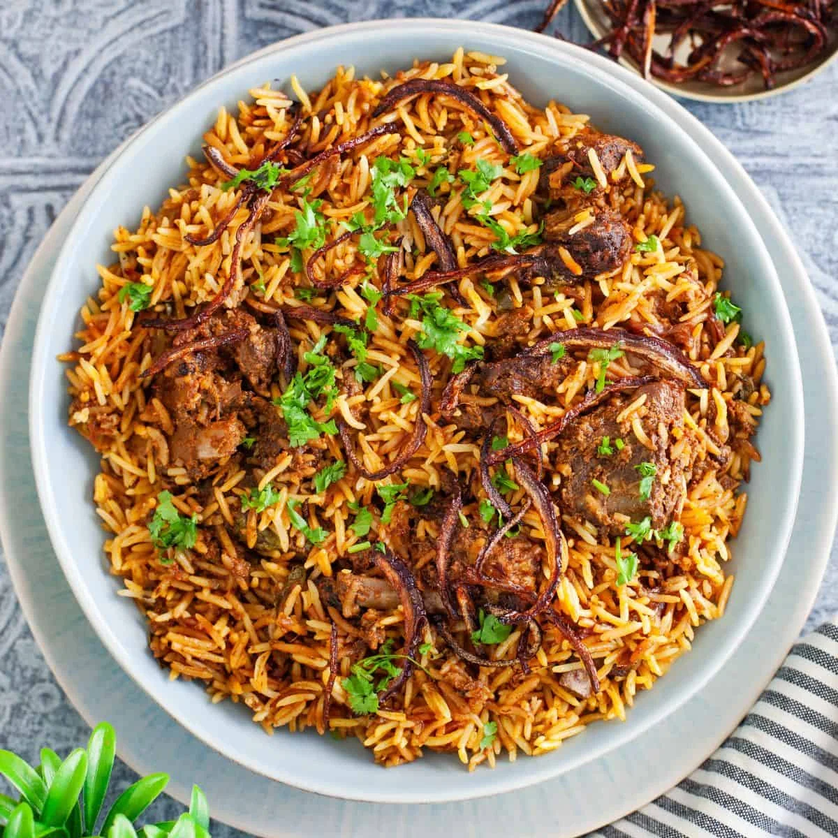 Nigerian jollof rice with tender meat and crispy onions