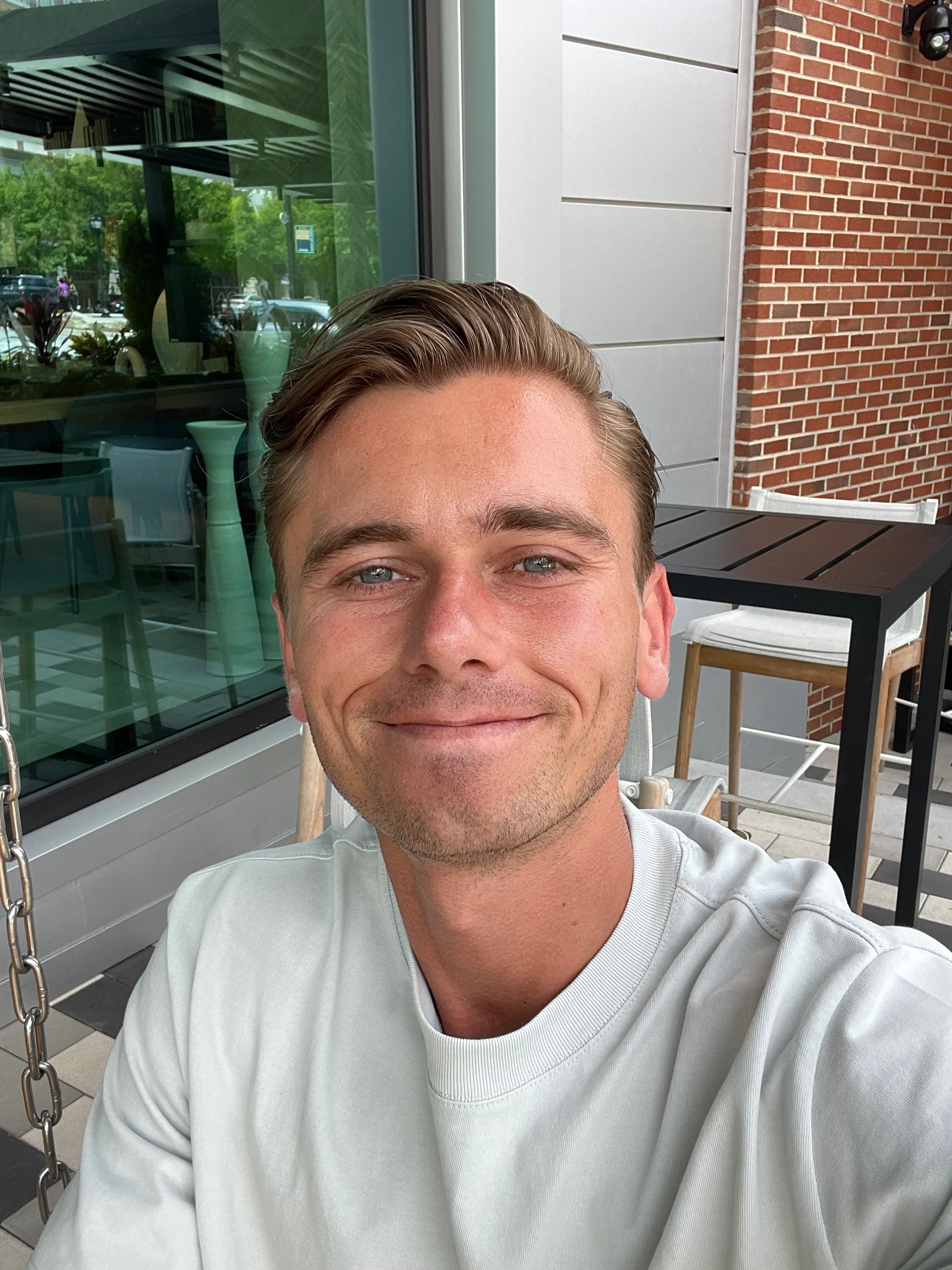 Smiling person enjoying a sunny day at a modern café