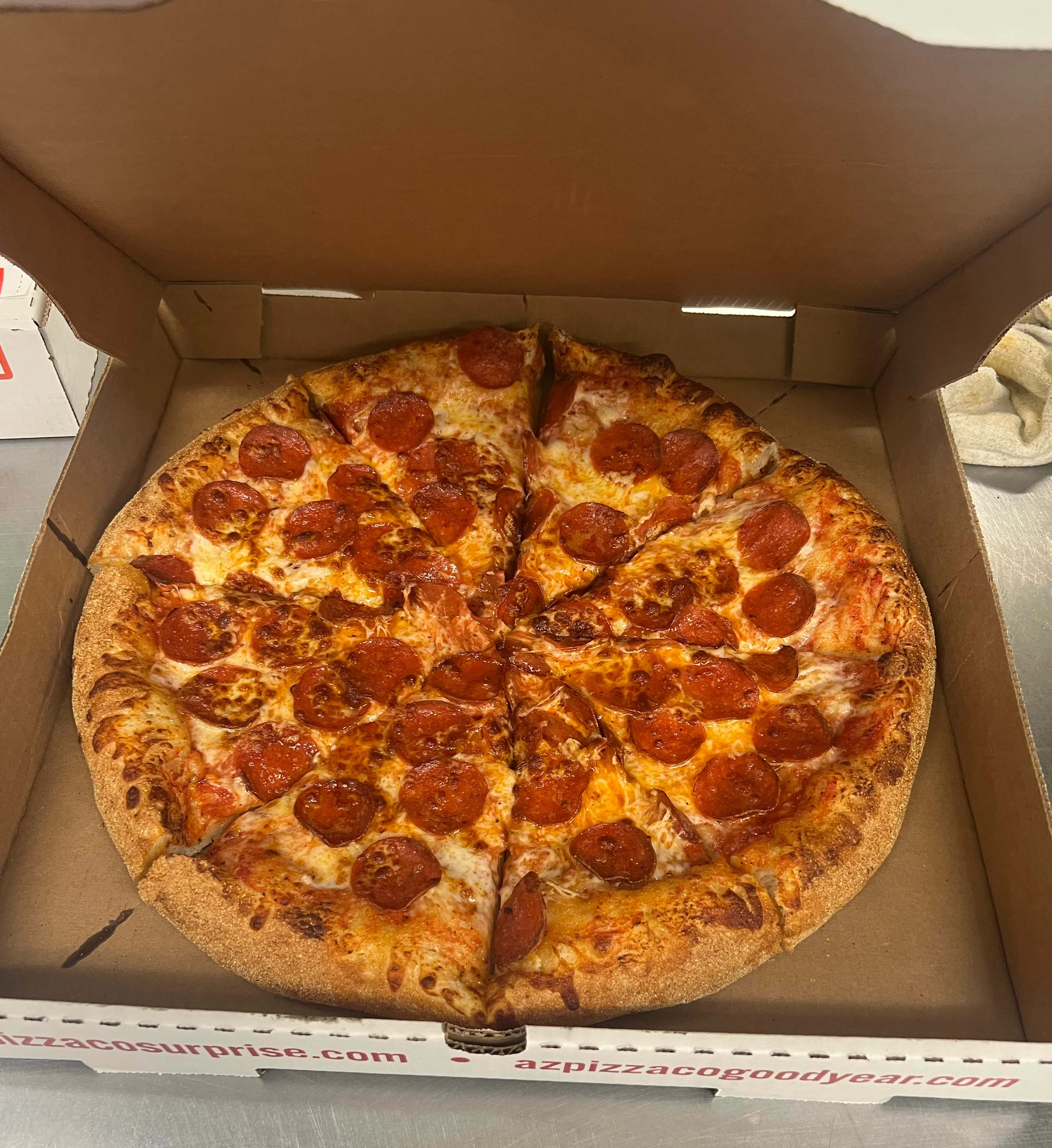 Pepperoni pizza in a classic takeout box