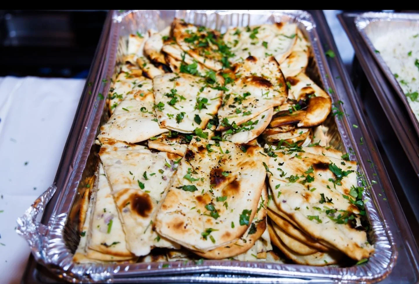 Freshly baked naan bread garnished with herbs