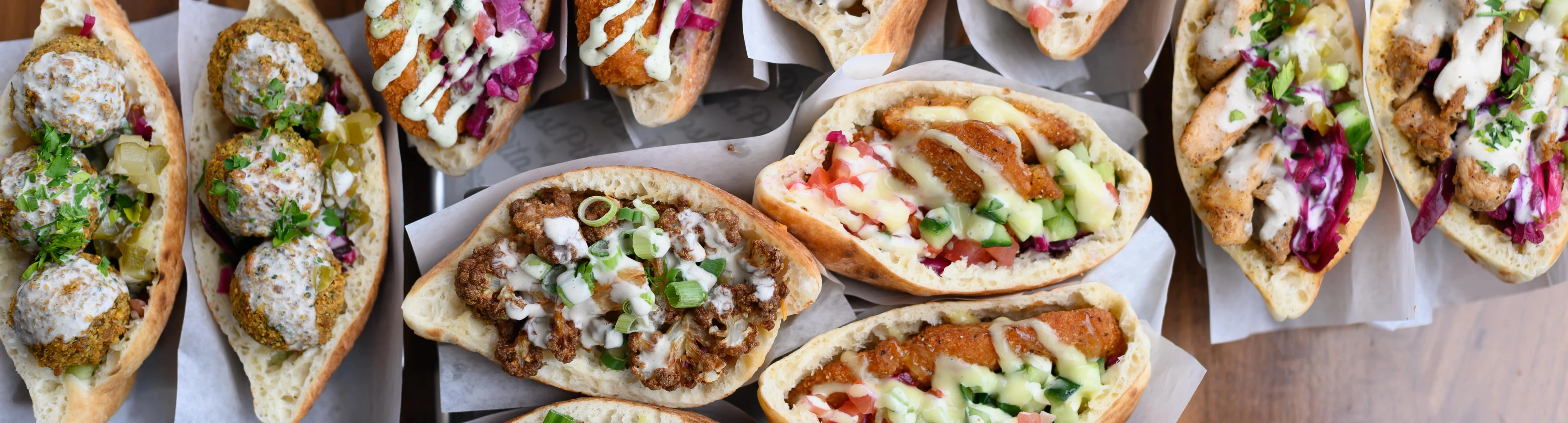 A group of people waiting for their order at the Pita Post