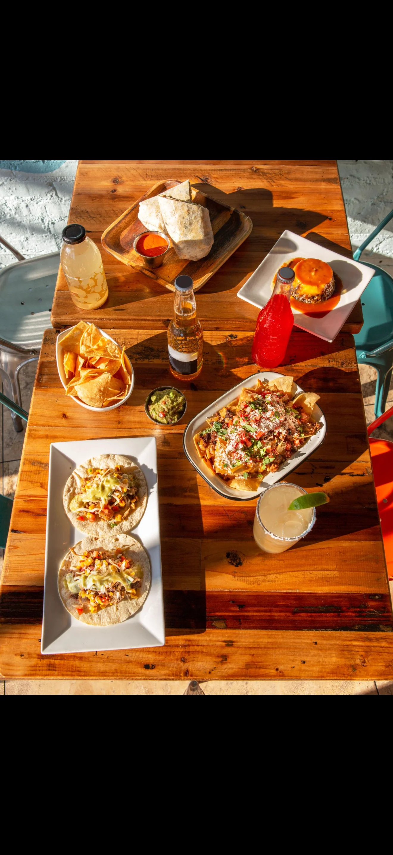 Colorful Mexican feast with tacos, nachos, and drinks