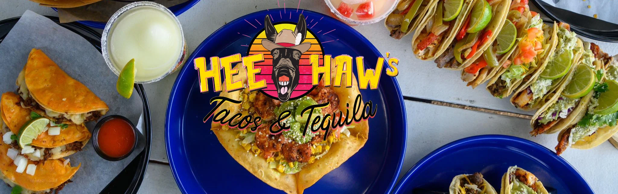 A vibrant display of tacos and a creamy drink, showcasing a variety of toppings and drinks in a lively dining setting.