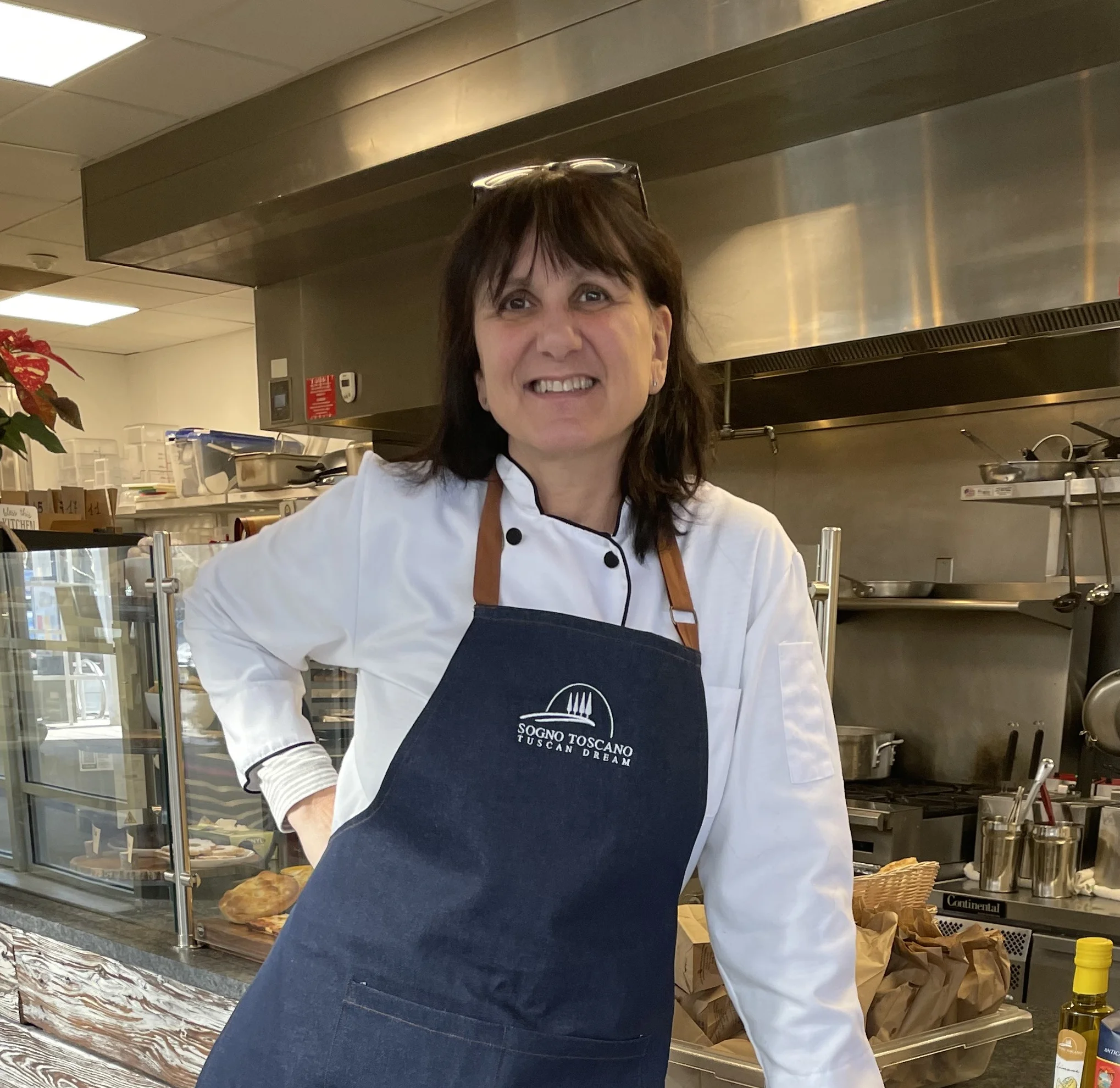 Chef in a cozy restaurant kitchen with a welcoming smile