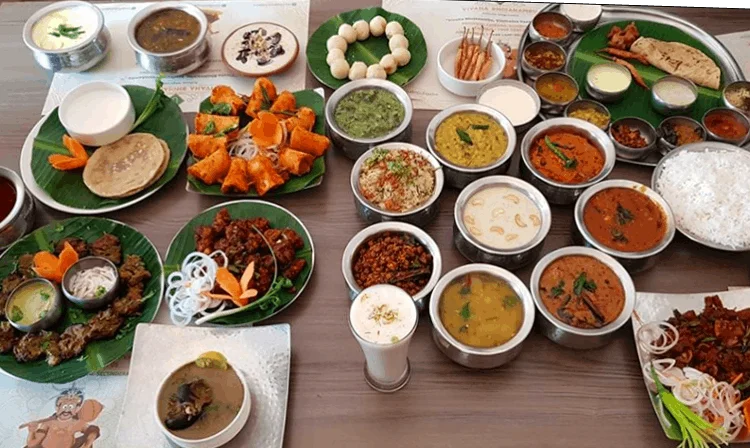 Indian thali with various curries and naan bread