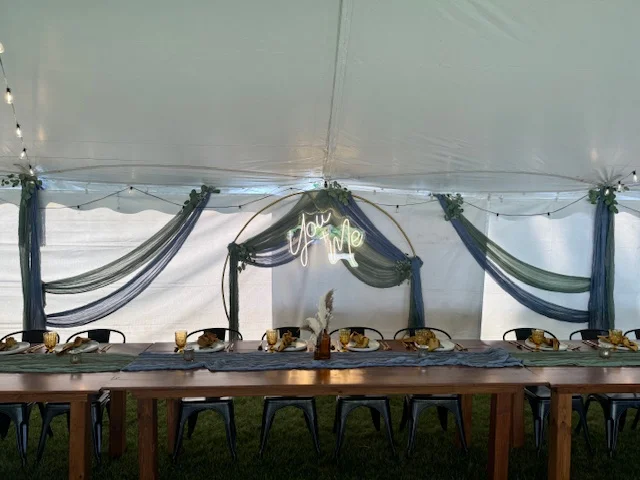 Elegant dining setup under a tent with decorative drapes