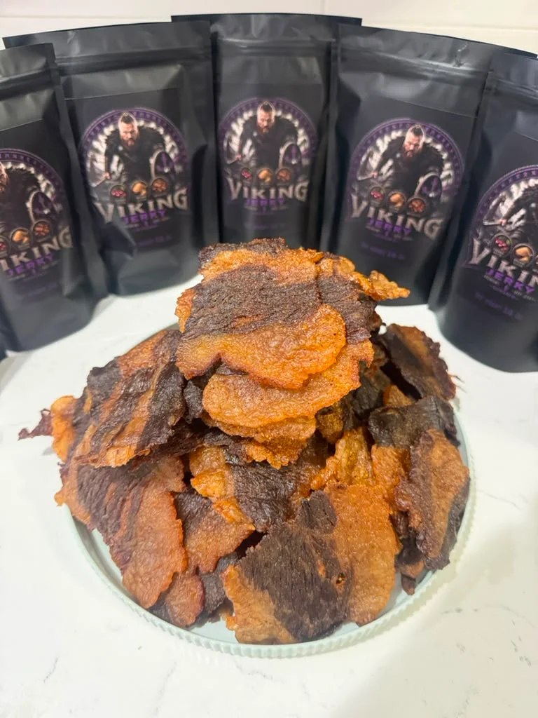 A dynamic label design for Viking Jerky showcasing maple and bourbon flavors, featuring a fierce warrior with a shield.