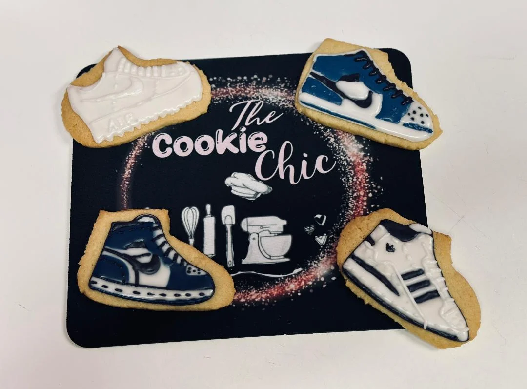 Decorative sneaker-shaped cookies on a branded mat