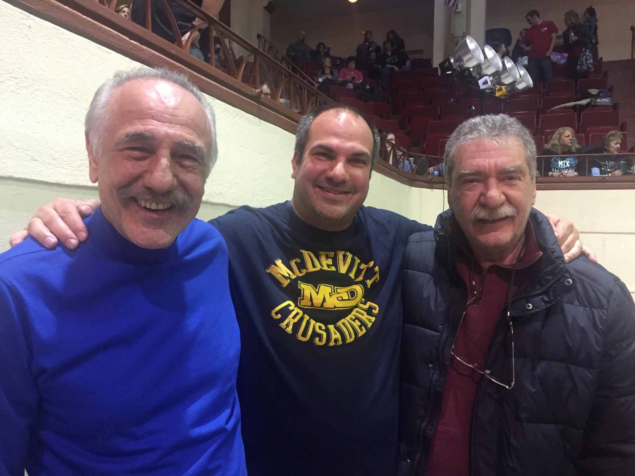 Three friends smiling together at an event