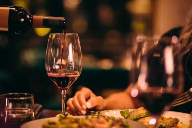 Pouring red wine into a glass at a fine dining restaurant