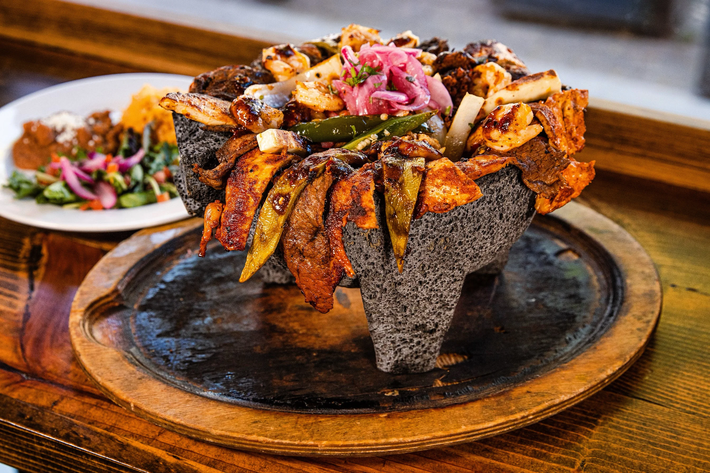 Sizzling Mexican fajitas served in a volcanic stone bowl