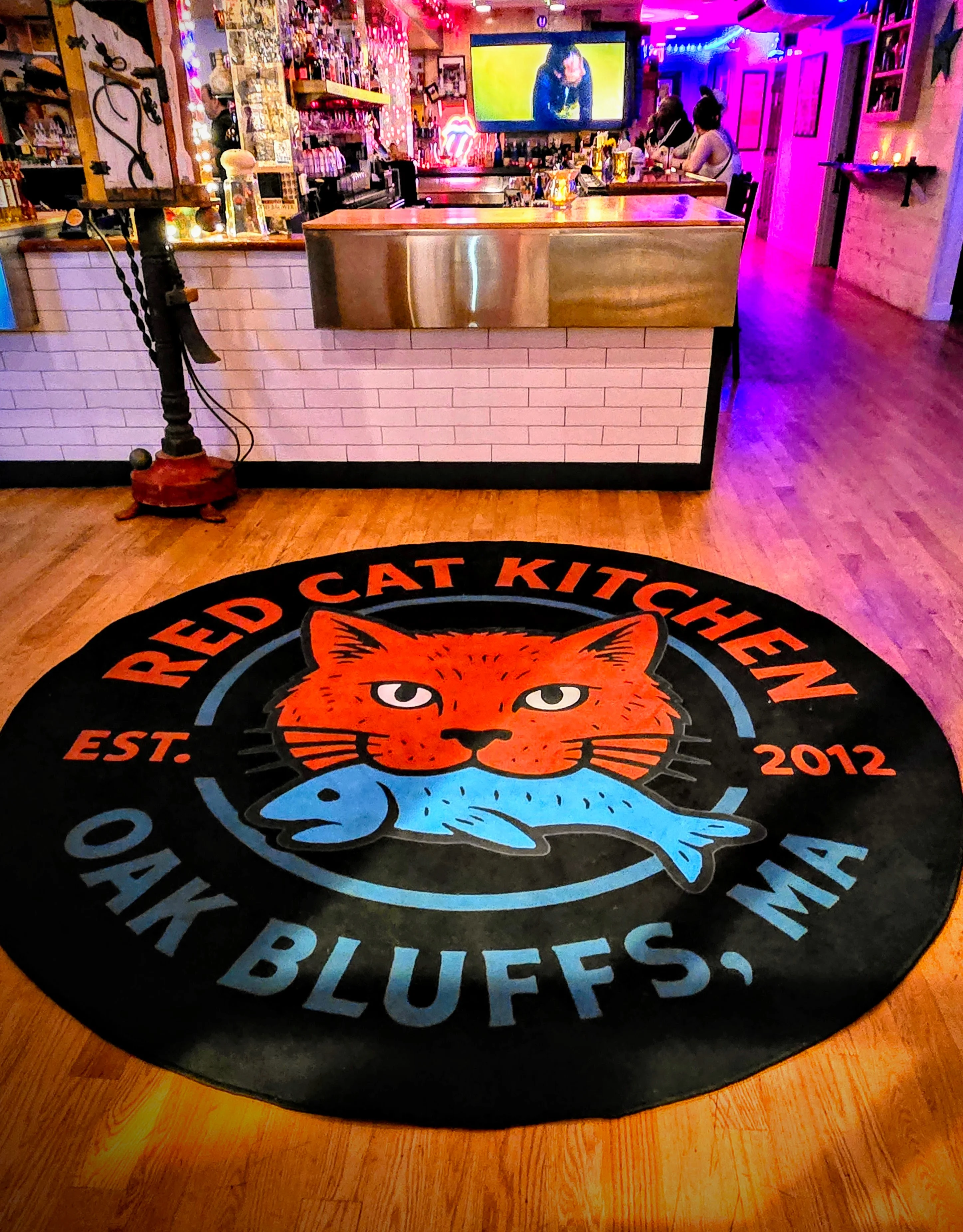 Interior of Red Cat Kitchen with logo rug and bar area in Oak Bluffs, MA.