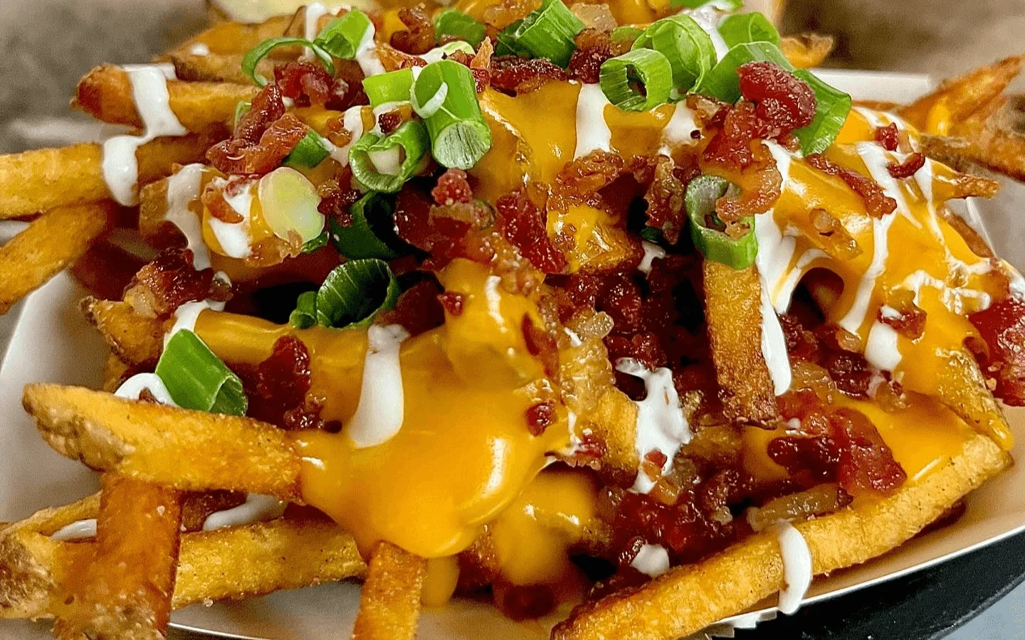 Loaded cheese fries topped with bacon and green onions