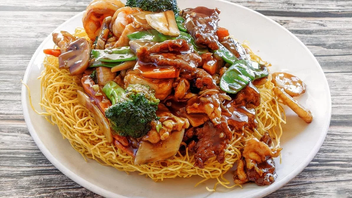 Crispy Cantonese chow mein topped with mixed vegetables and savory sauce