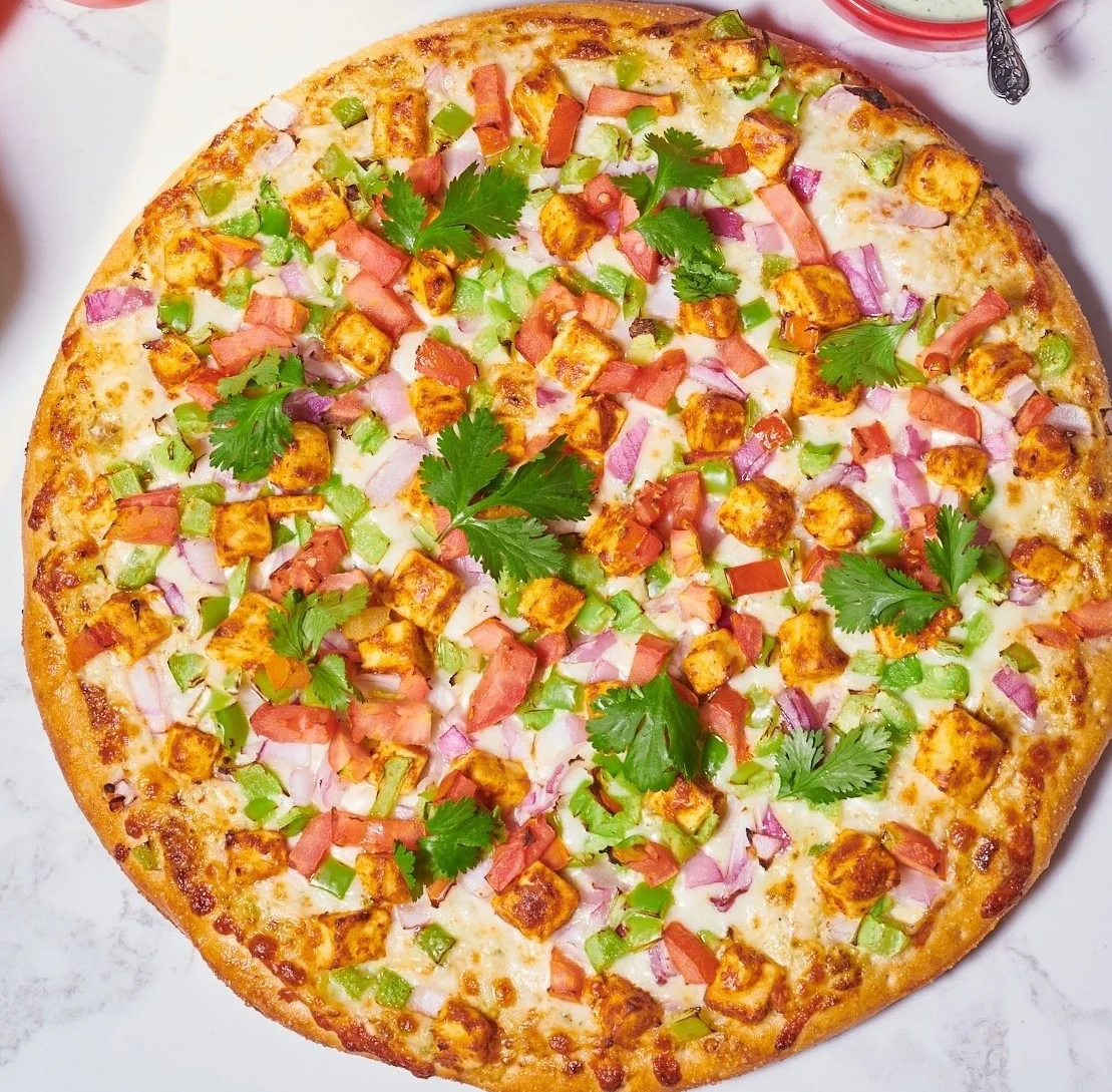 Vegetarian pizza topped with fresh herbs and vegetables