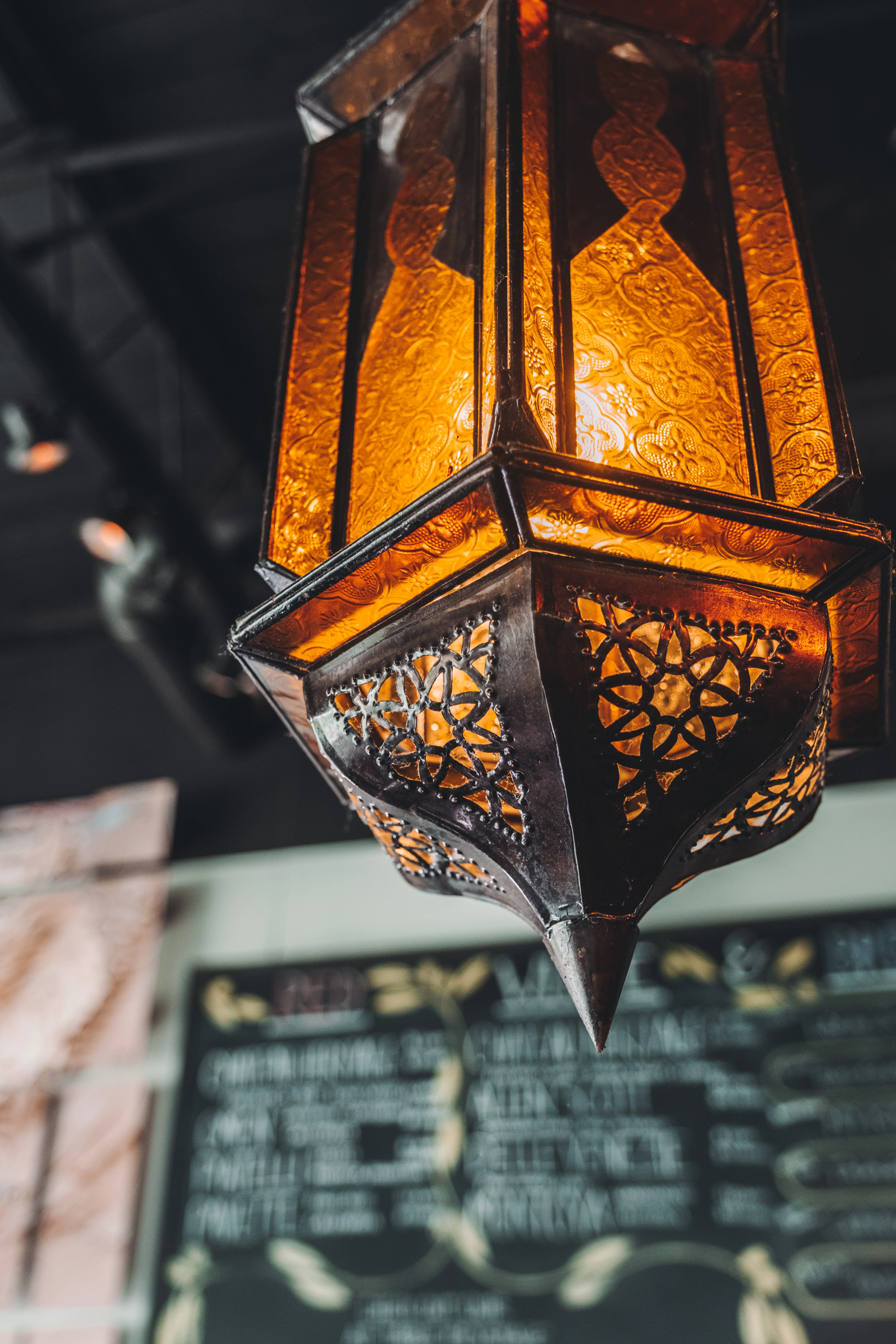 Intricate Moroccan lantern illuminating a cozy restaurant interior
