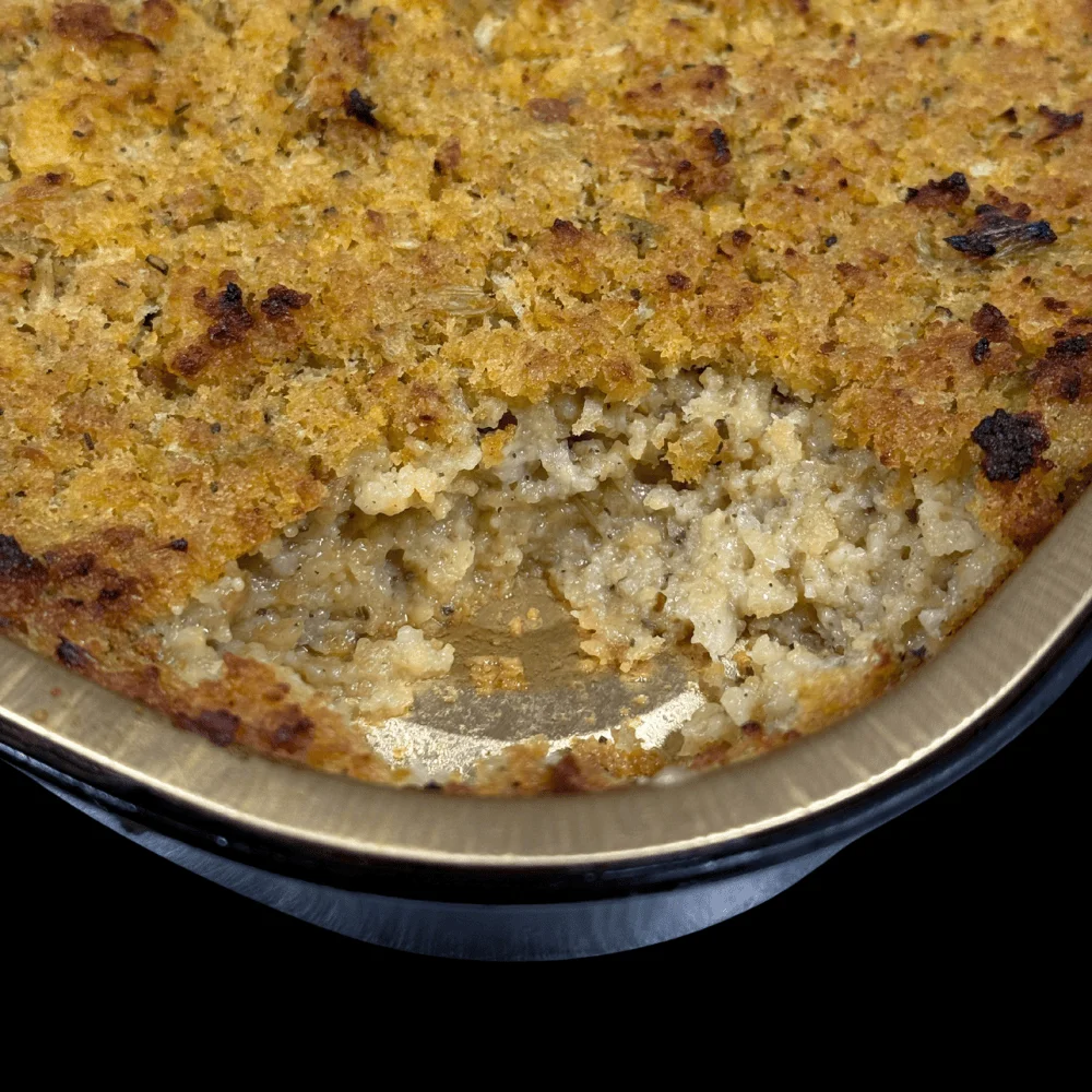 Baked dish with a golden crust and creamy filling, partially served.