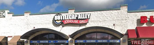 The front view of an ice house grill with a large sign and multiple service windows. The building has a clean, white exterior and is situated in a shopping area.