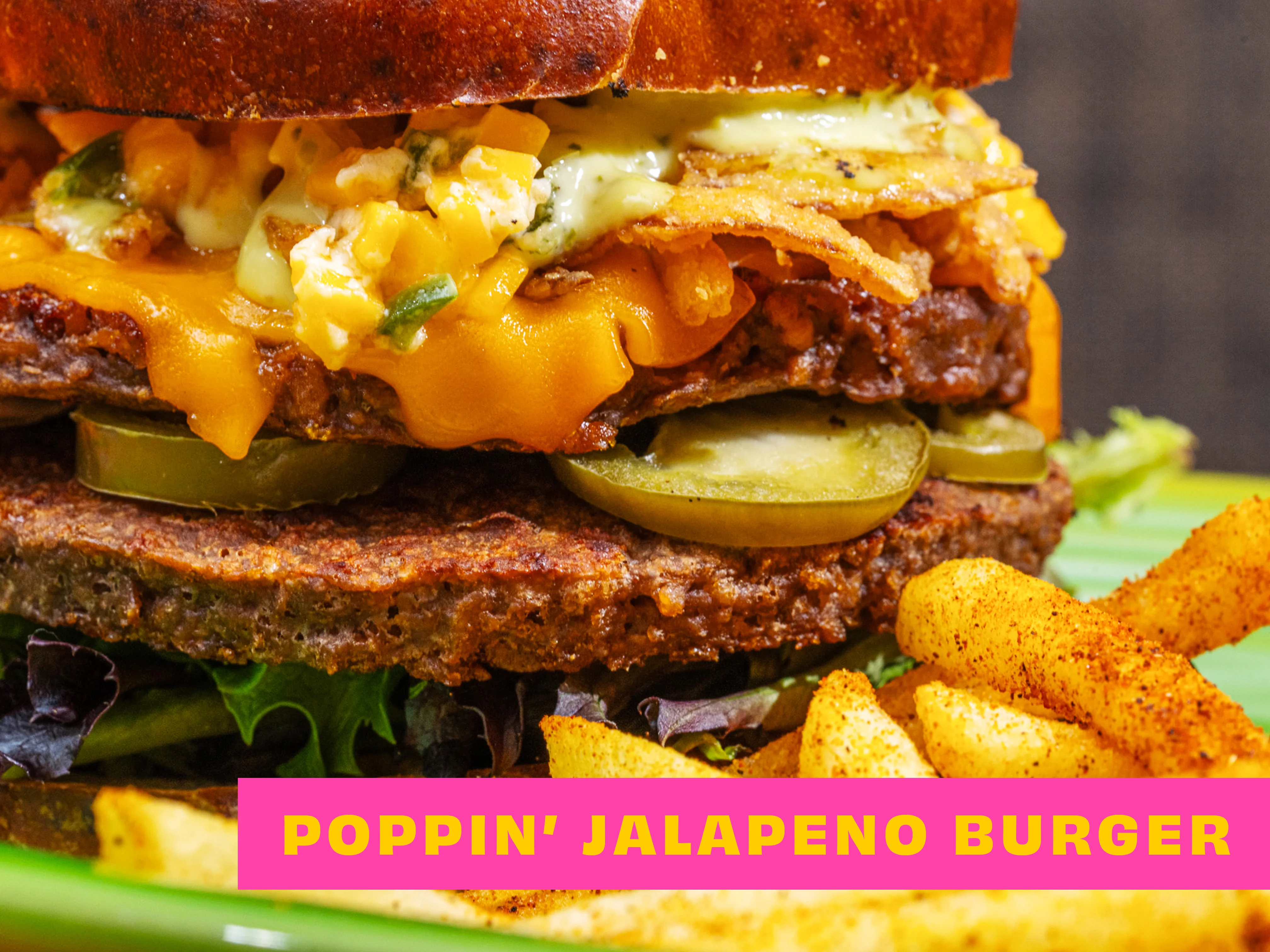 A hearty burger topped with cheddar cheese, jalapenos, and crispy onions, served with fries.