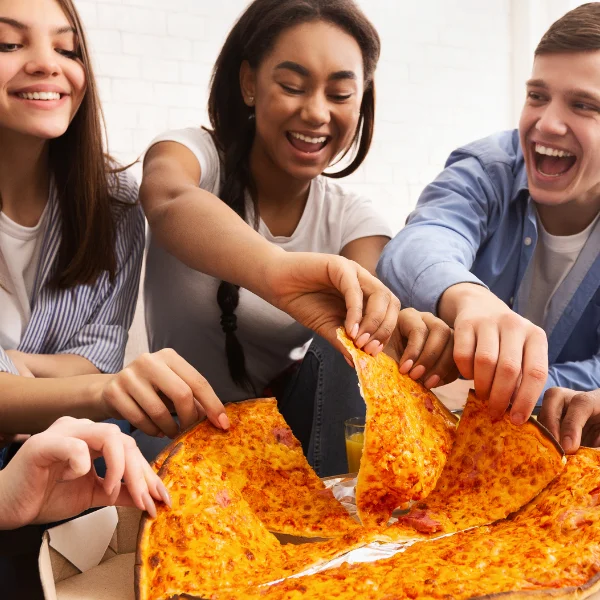 Group of friends sharing a large cheese pizza