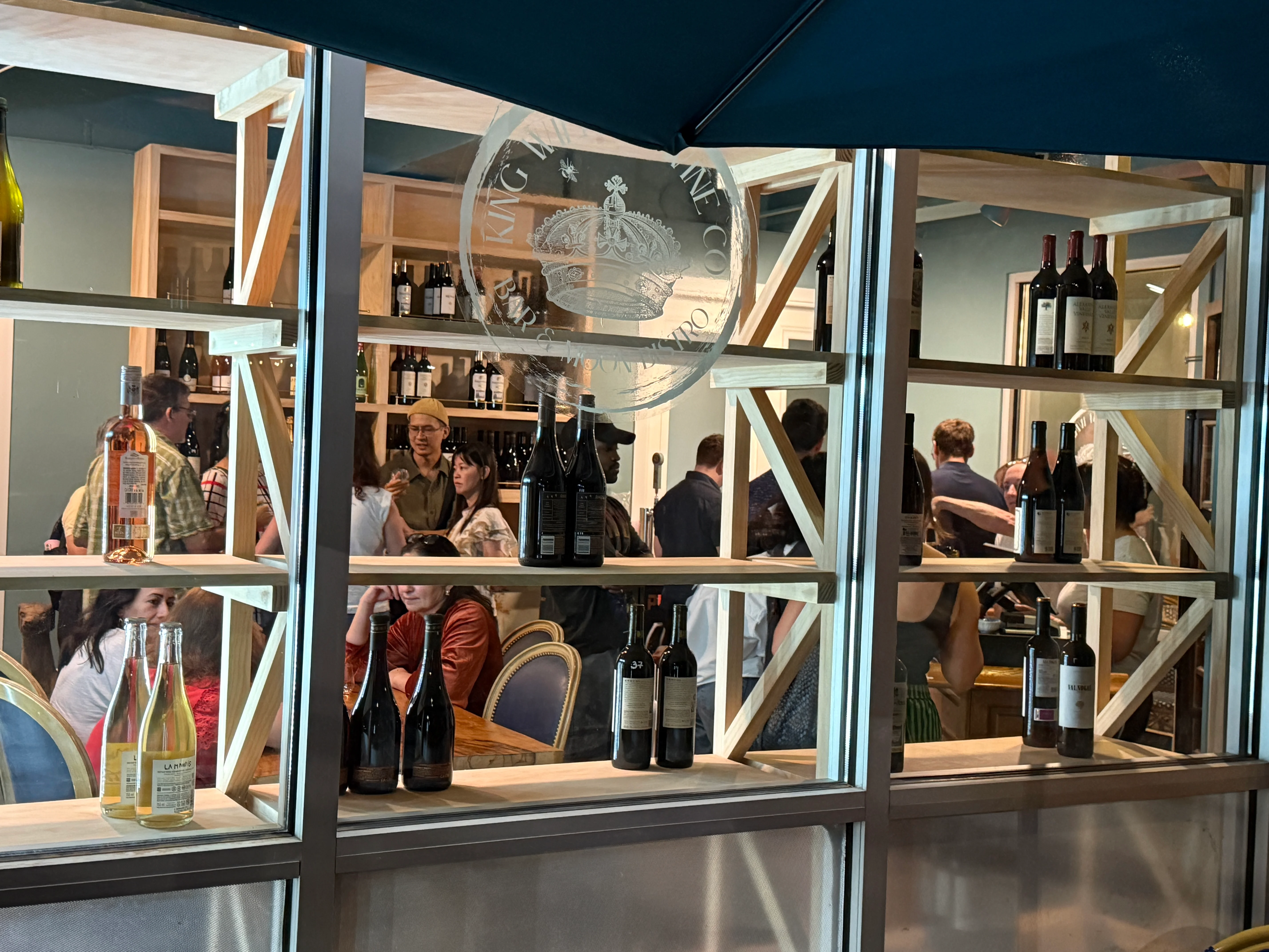 Cozy restaurant interior with wine bottles and patrons enjoying their evening