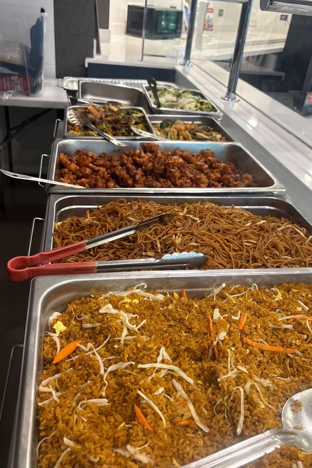Catering buffet with chafing dishes of Chinese entrees and noodles