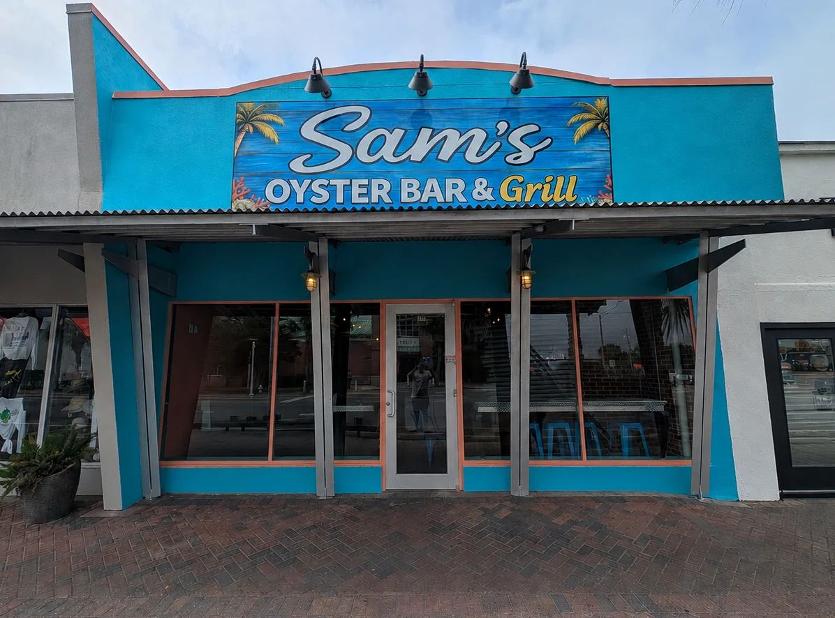 Vibrant exterior of Sam's Oyster Bar & Grill with tropical decor